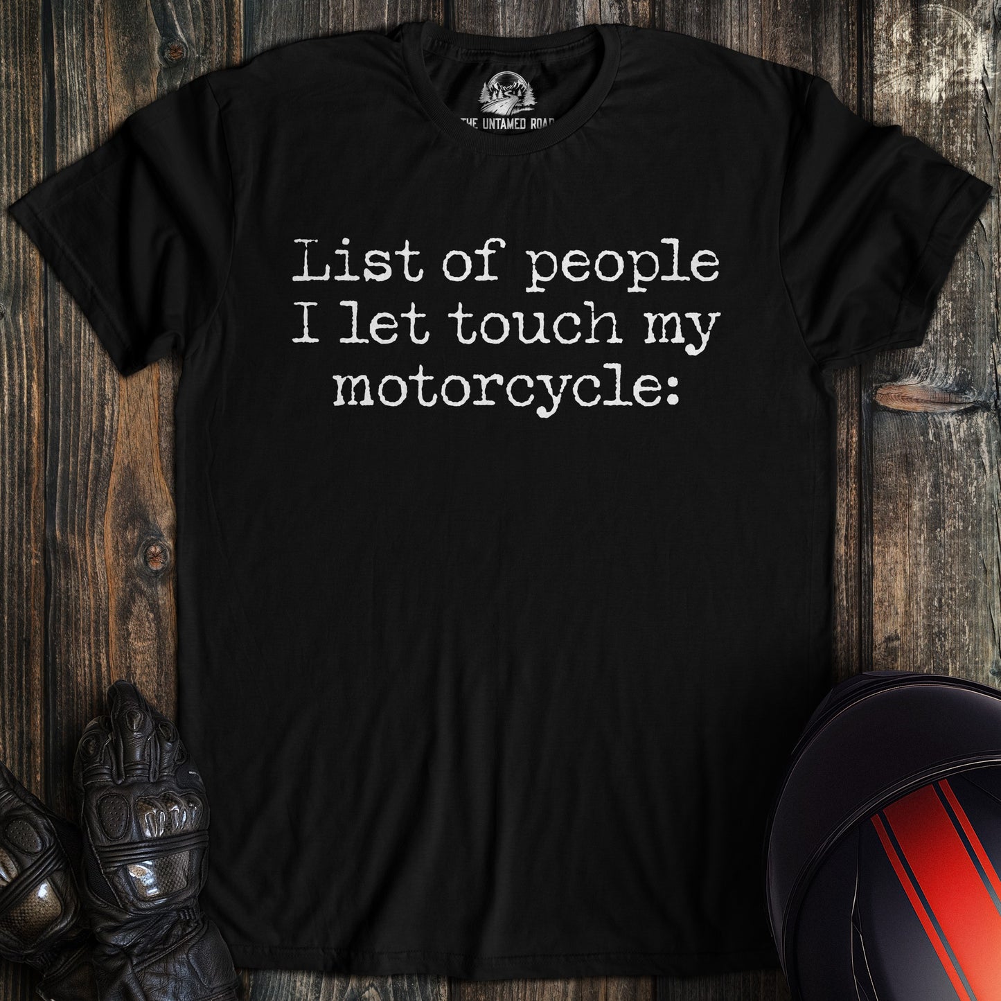 A black t-shirt featuring the text "List of people I let touch my motorcycle:" in a white typewriter font.