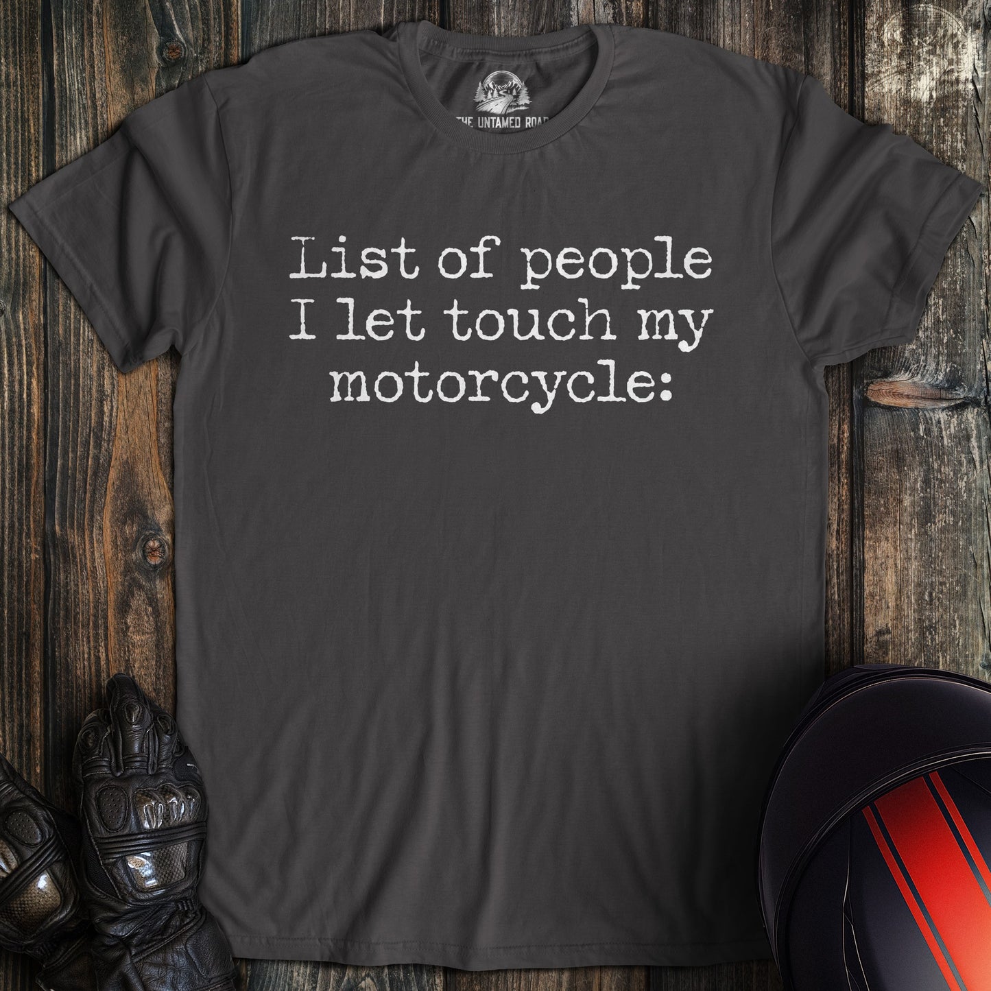 A charcoal gray t-shirt with the text 'List of people I let touch my motorcycle:' printed in white typewriter font.