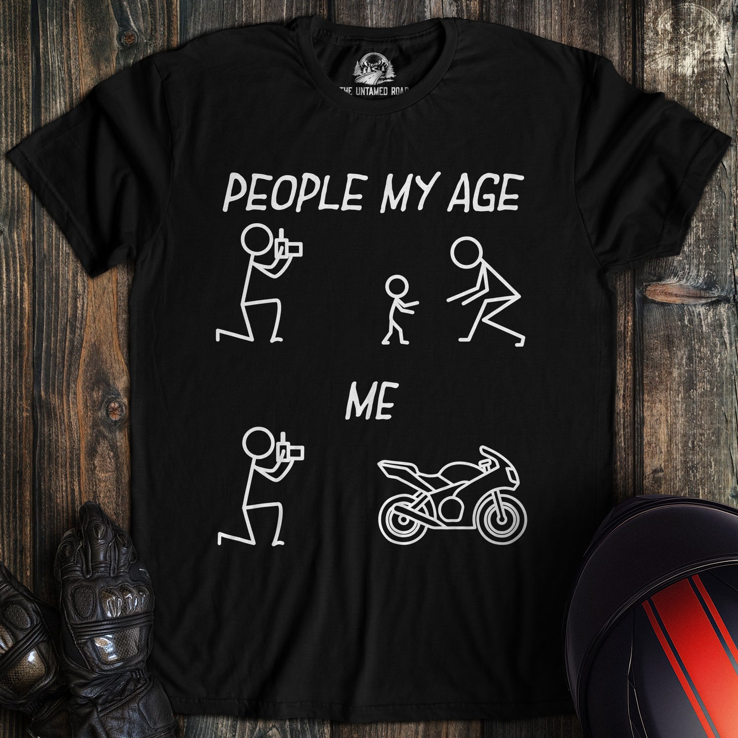 A black t-shirt featuring a funny biker graphic comparing people my age with families to me with a motorcycle.