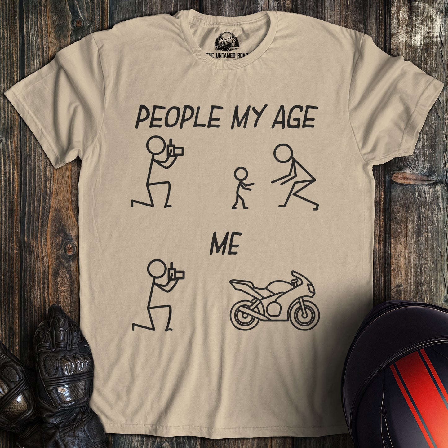 A sand colored t-shirt with a funny graphic comparing people my age with kids to me with a motorcycle.
