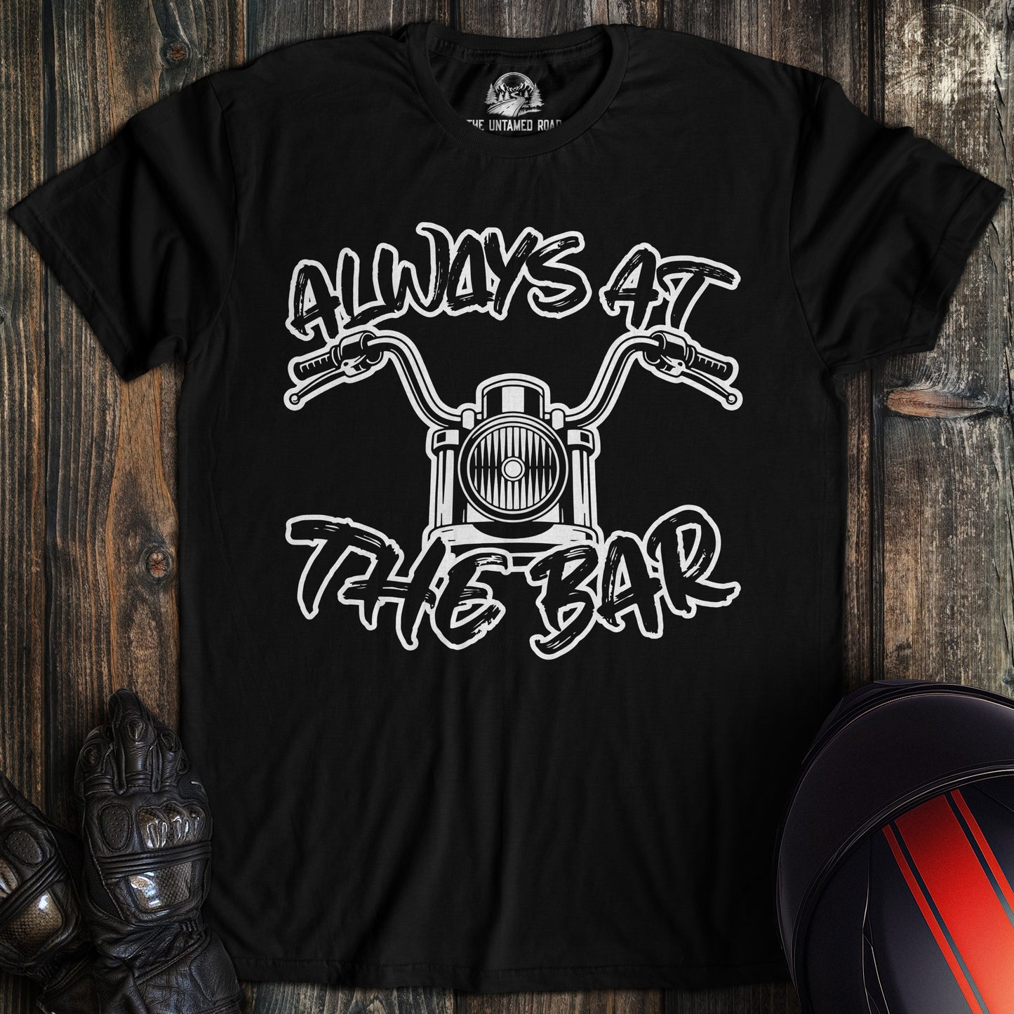 A black t-shirt featuring a white graphic of motorcycle handlebars and the text Always At The Bar.