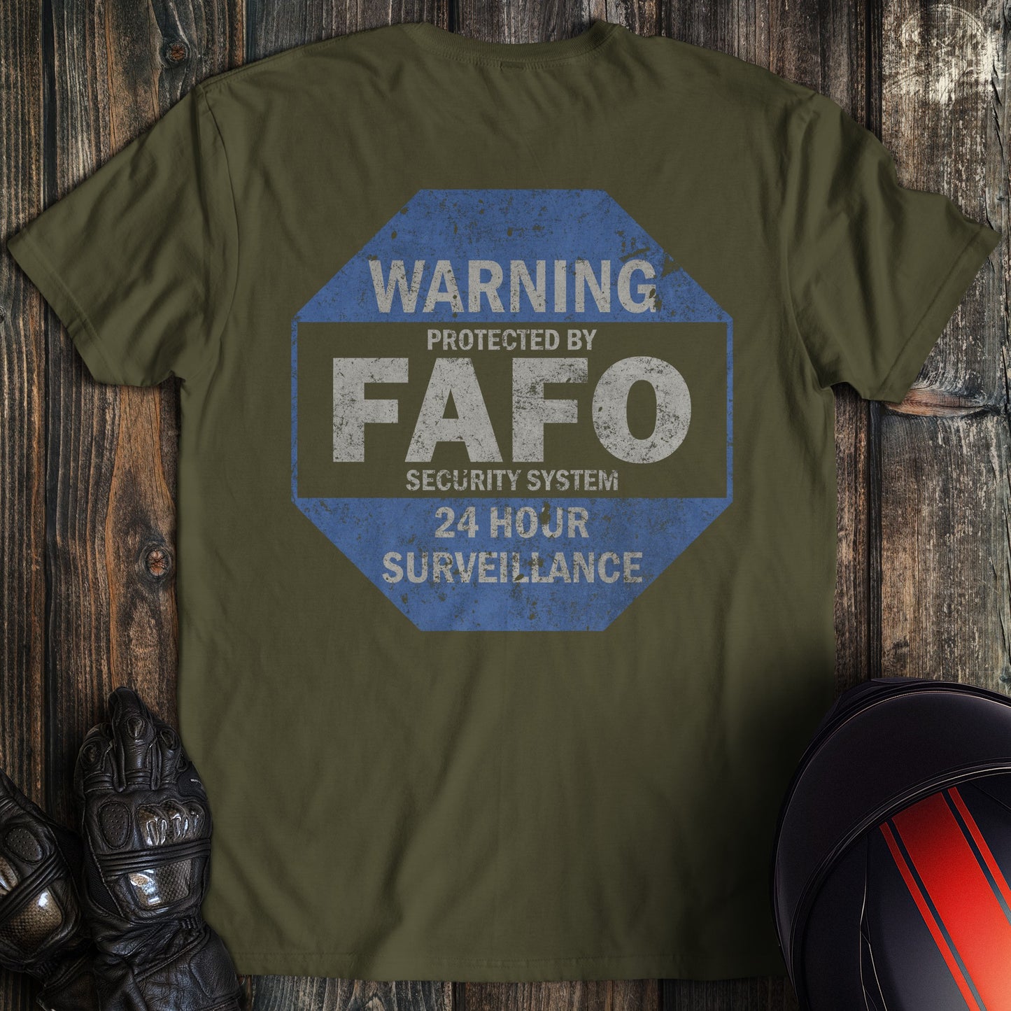 Military green t-shirt with a blue octagonal graphic reading Warning Protected by FAFO Security System 24 Hour Surveillance.