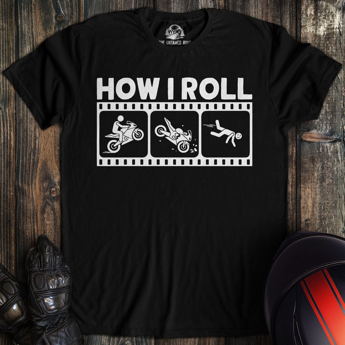 A black t-shirt featuring a funny motorcycle graphic with the text HOW I ROLL and a biker falling off a bike.