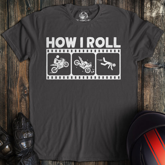 A charcoal gray t-shirt with a funny graphic of a motorcycle crash sequence and the text HOW I ROLL.