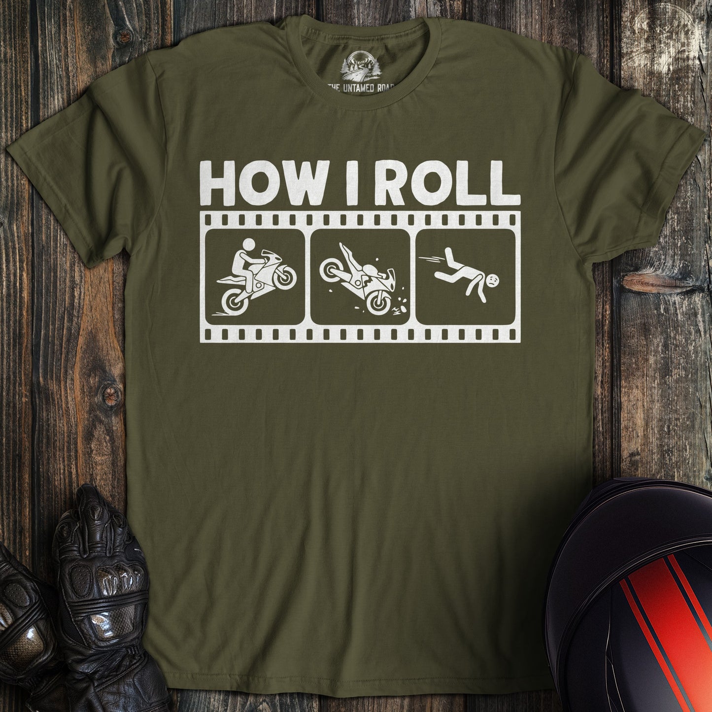 A military green t-shirt featuring a funny graphic of a biker falling off a motorcycle with the text HOW I ROLL.