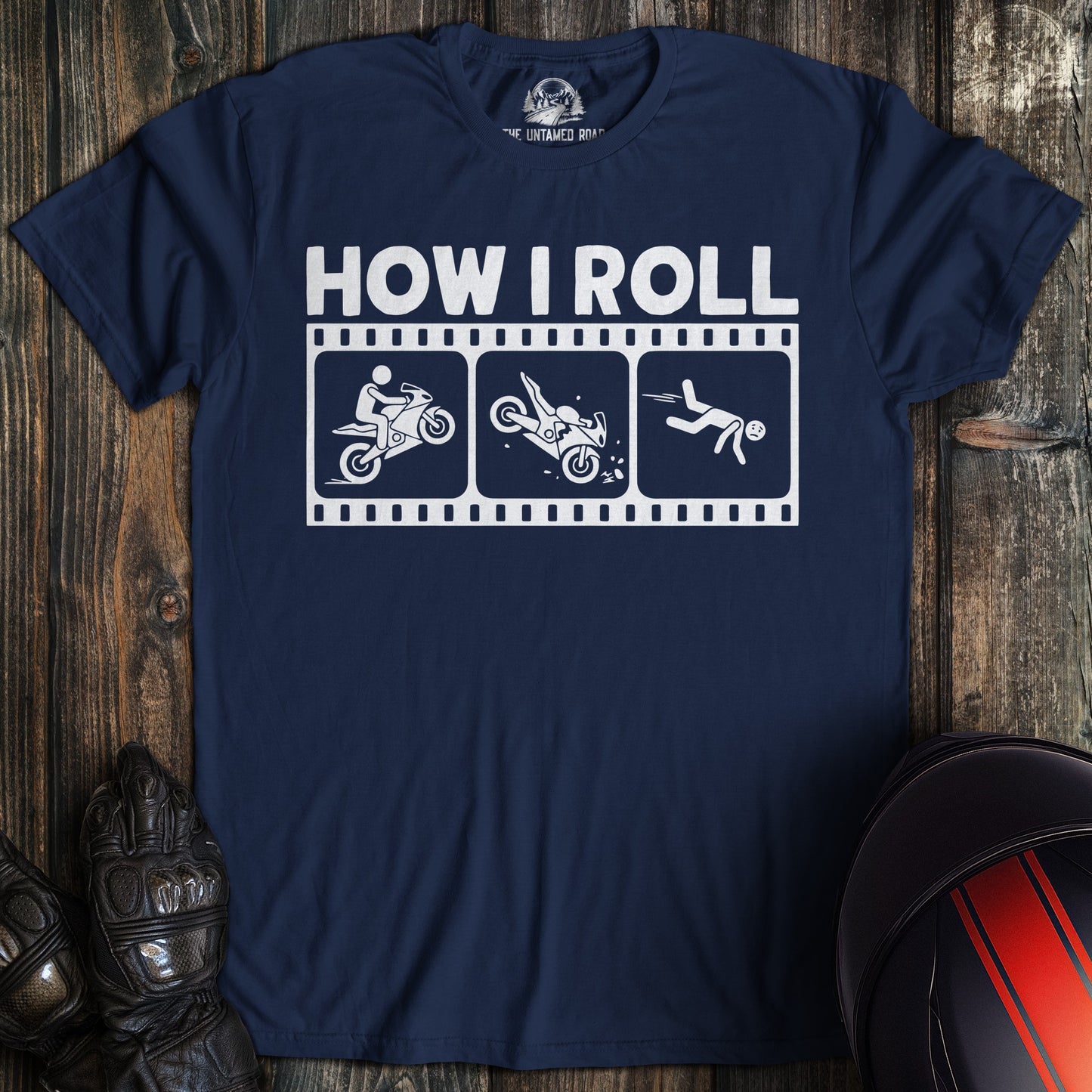 A navy blue t-shirt featuring a funny motorcycle crash sequence in a film strip with the text HOW I ROLL.