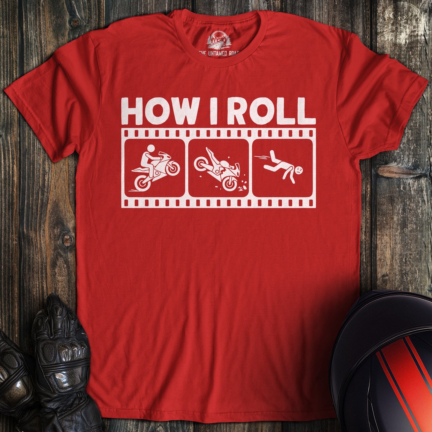 A red t-shirt with a funny biker graphic showing a motorcycle crash sequence under the text HOW I ROLL.