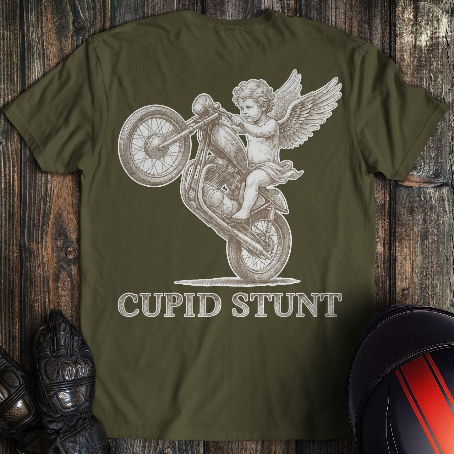 A military green t-shirt featuring a winged cupid performing a wheelie on a motorcycle with the text CUPID STUNT.