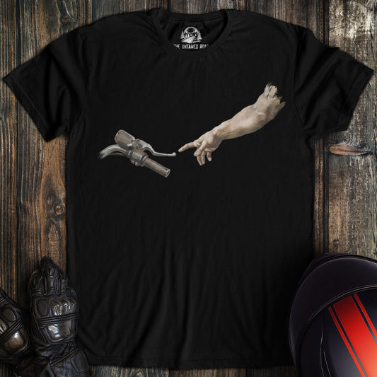 A black t-shirt featuring a funny graphic of a hand reaching out to touch a motorcycle handlebar in a parody of Creation.