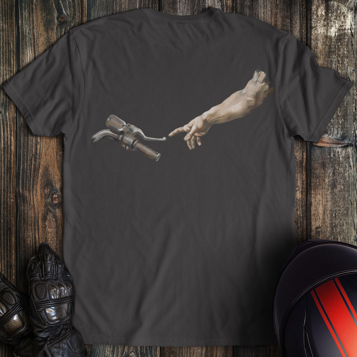 Charcoal gray t-shirt featuring a funny biker graphic of a hand reaching for a motorcycle handlebar in a creation style.