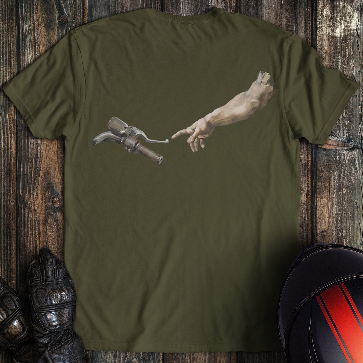 A military green t-shirt featuring a funny graphic of a hand reaching for a motorcycle handlebar in a creation style.