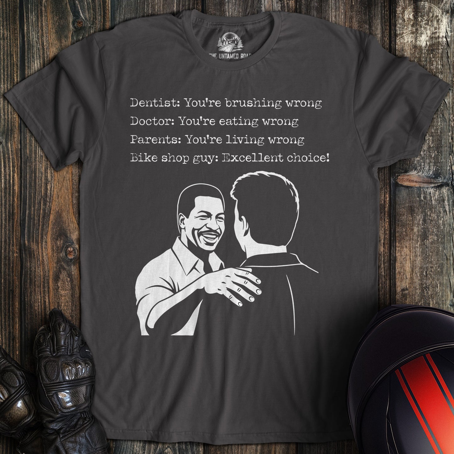 A charcoal gray t-shirt featuring a funny biker graphic and text about a bike shop guy saying, "Excellent choice!"