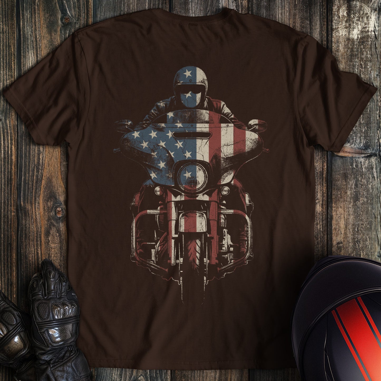 A dark brown crew neck t-shirt featuring a graphic of a biker on a motorcycle with an American flag overlay.