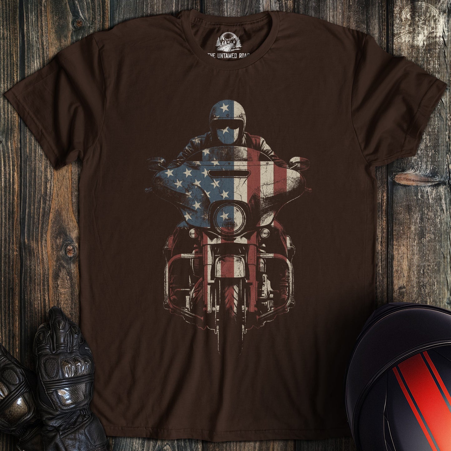A dark brown crew neck t-shirt featuring a biker on a motorcycle with an American flag graphic overlay.