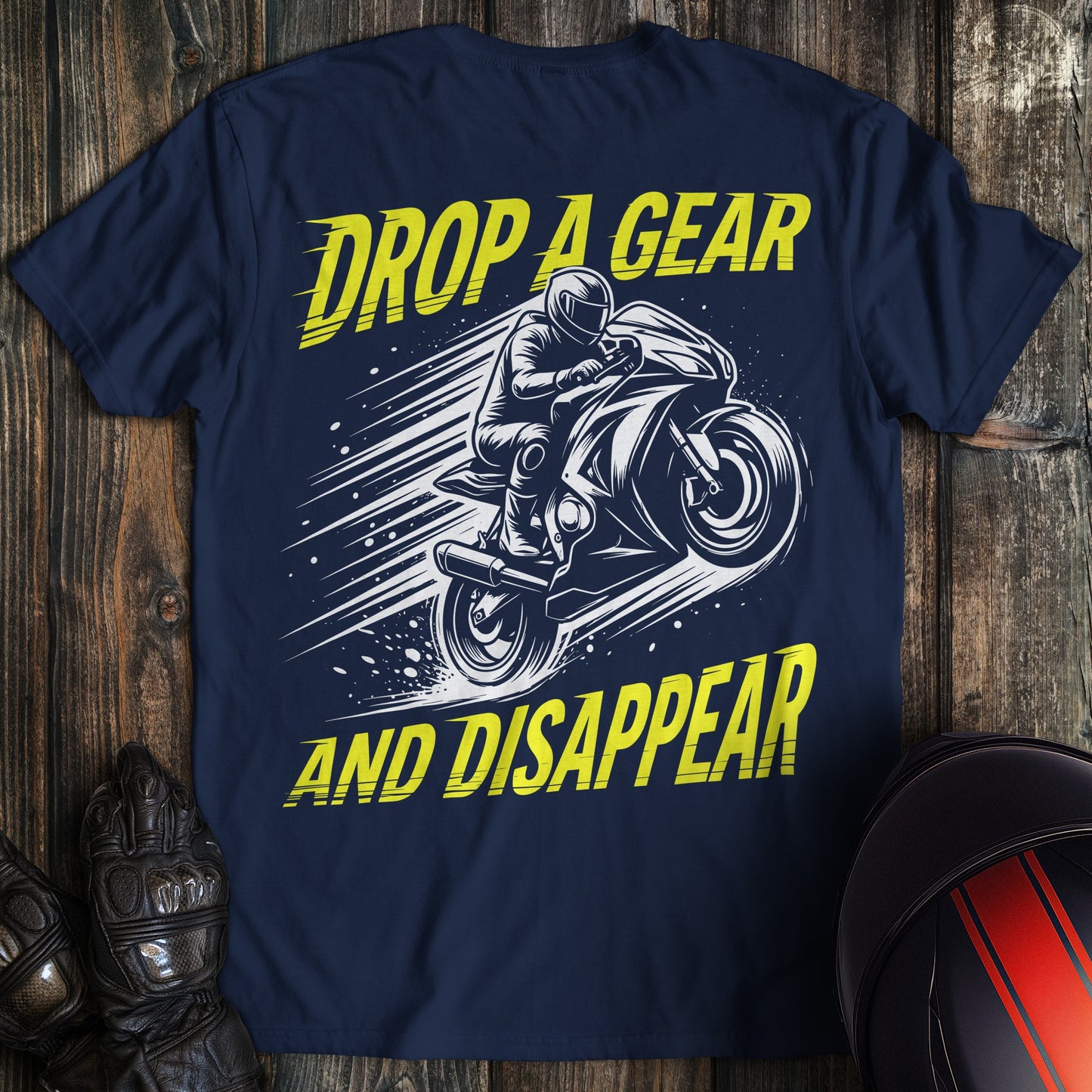 A navy blue t-shirt featuring a motorcycle graphic and the text Drop A Gear and Disappear in yellow.