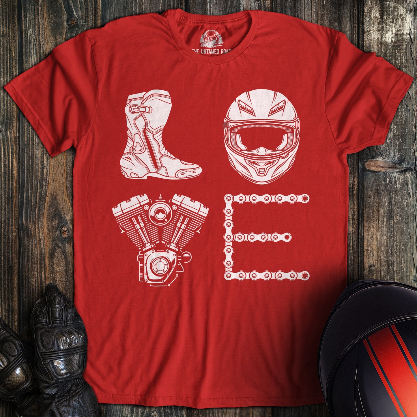 A red t-shirt featuring white graphics of a biker boot, helmet, motorcycle engine, and chain spelling the word LOVE.